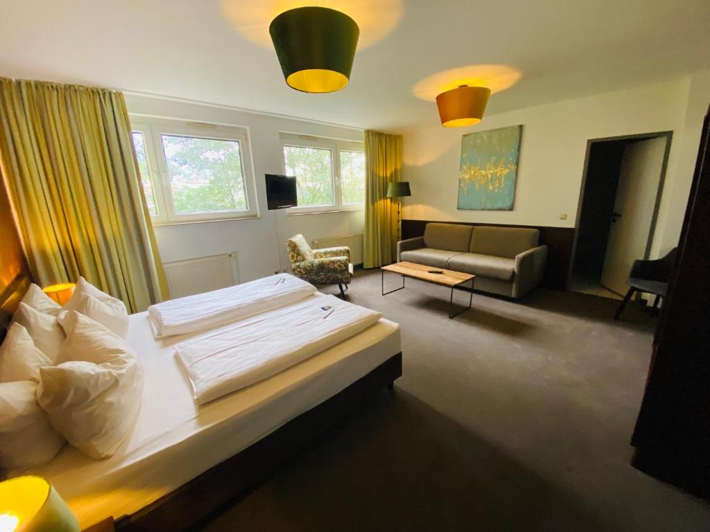 une chambre d'hôtel avec un lit et un canapé dans l'établissement Hotel Christina, à Cologne