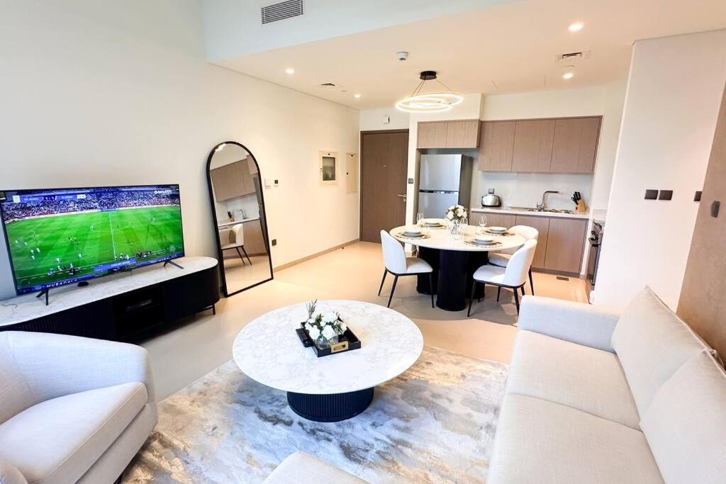 een woonkamer met een bank, een tv en een tafel bij MH - Act Tower - Burj View - 2BHK - Ref 410 in Dubai