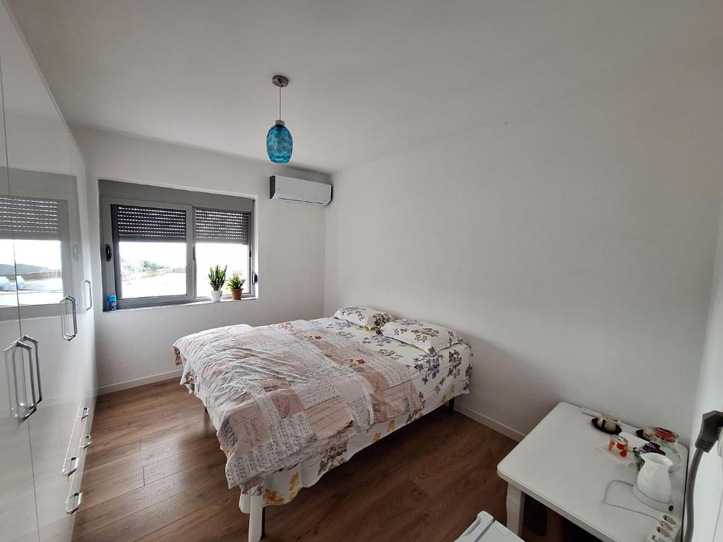 a white bedroom with a bed and a kitchen at Ergi's Host Apartment in Krujë