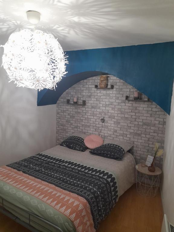 ein Schlafzimmer mit einem großen Bett mit Ziegelwand in der Unterkunft Vue exceptionnelle aux portes du Vercors in Pont-en-Royans