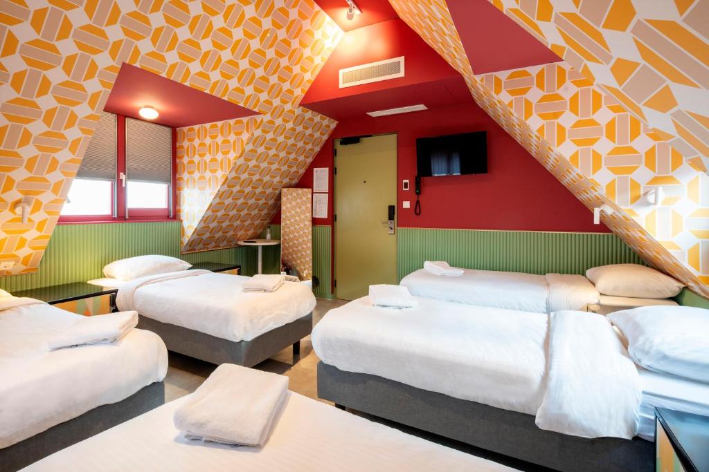 アムステルダムにあるバジェット ホテル ツーリスト インのベッドが備わる客室です。