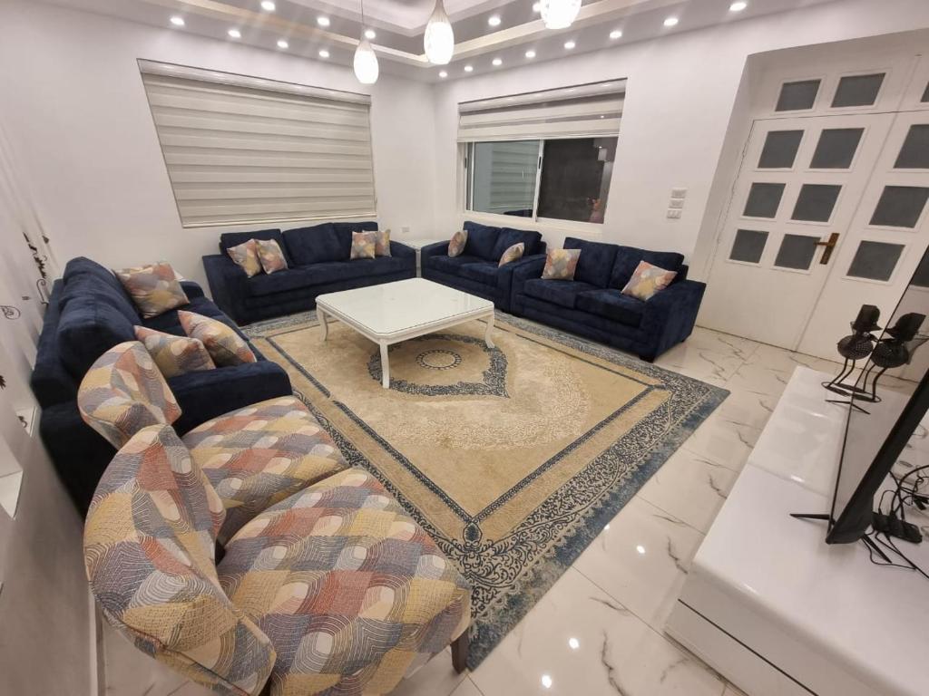 a living room with couches and a coffee table at منتجعات روابي القمر 