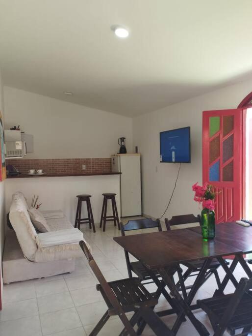ein Wohnzimmer mit einem Tisch und einer Küche in der Unterkunft Casa na Praia de itacimirim Vila Maria in Camassari