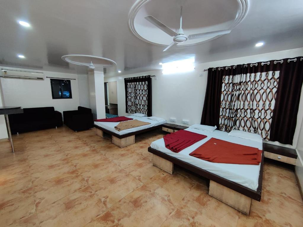 a bedroom with two beds and a living room at Sai Anand in Nashik