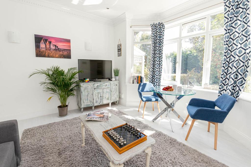 uma sala de estar com uma televisão e uma mesa em Modern flat, sleeps 4, close to beach,Parking,WiFi - Queens Park Views em Bournemouth