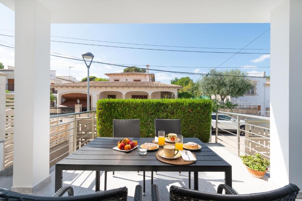 a table on a balcony with a bowl of fruit at Villa Isabel in Playa de Muro