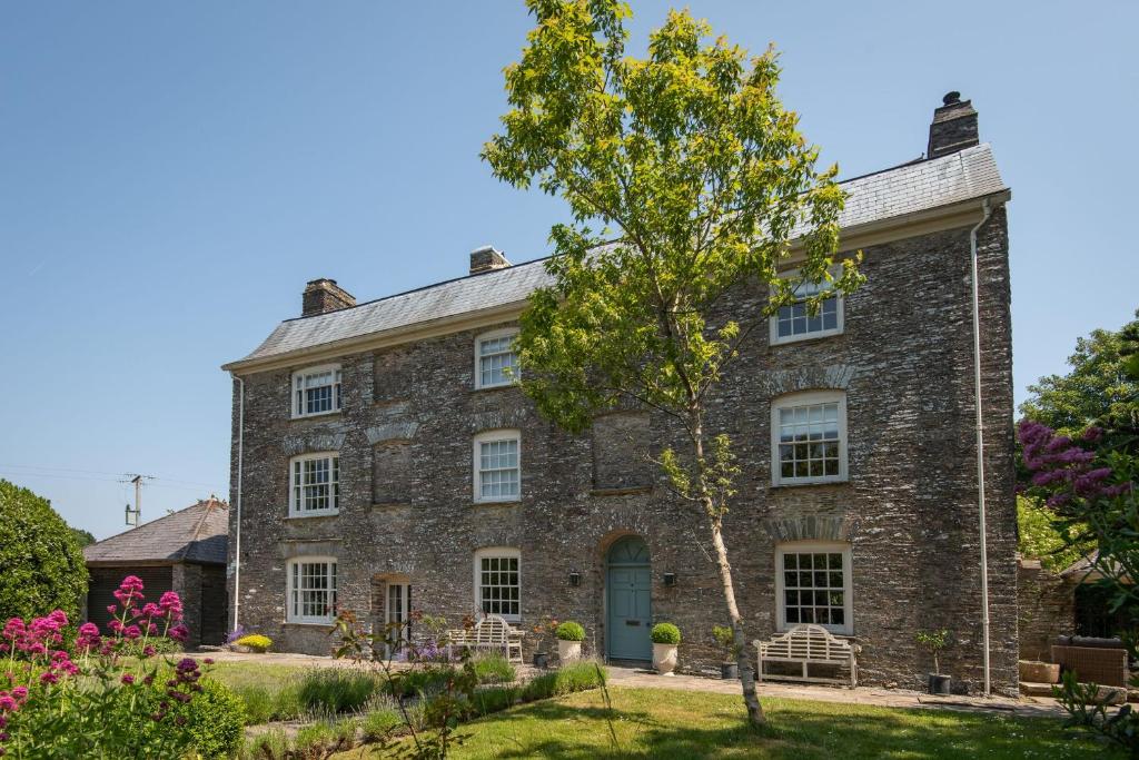 ein altes Steinhaus mit einem Baum im Hof in der Unterkunft Maberly House in South Pool