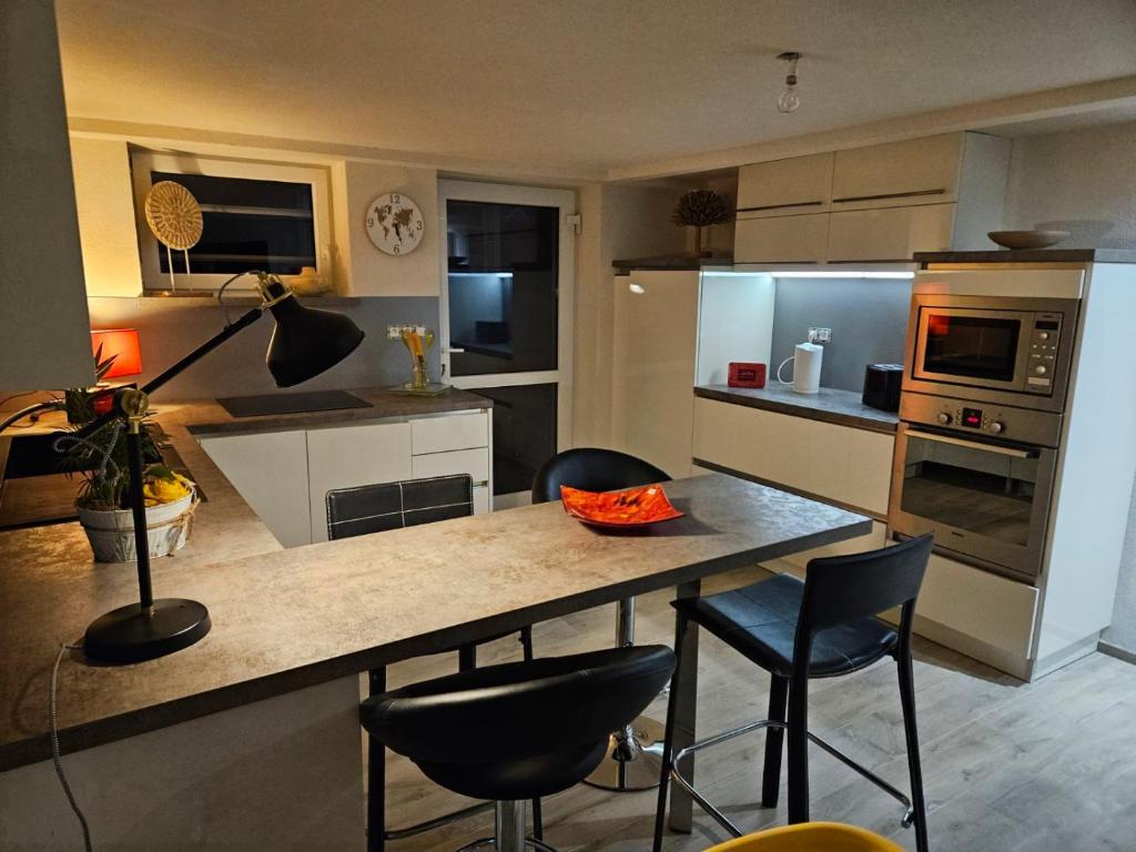 una cucina con tavolo e sedie in una stanza di Appartement neuf 1 à 6 personnes dans maison individuelle a Haguenau