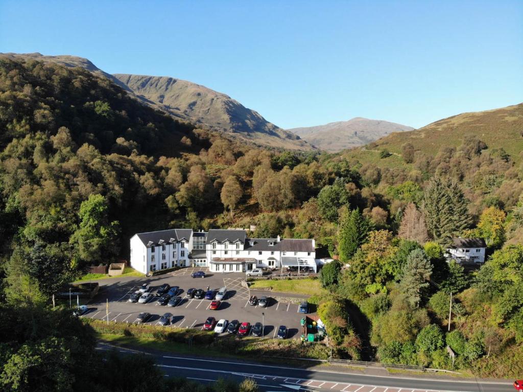 an aerial view of a hotel in the mountains at The Inn on Loch Lomond in Luss