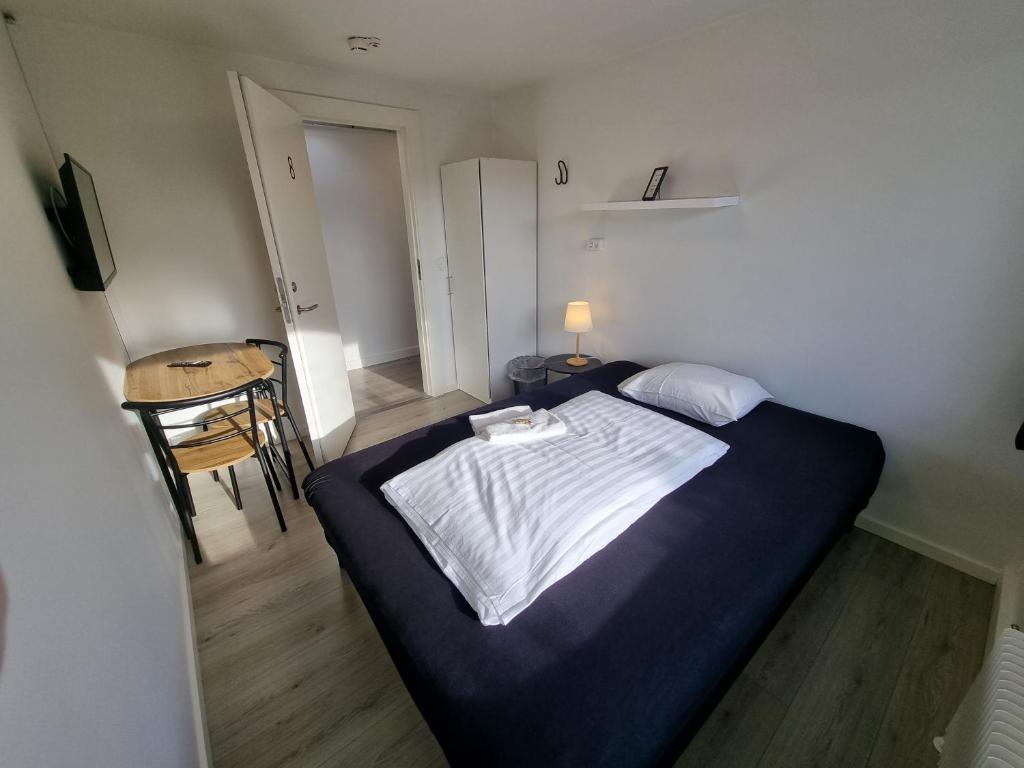 Dormitorio pequeño con cama y mesa en Slottets Anneks, en Rønne