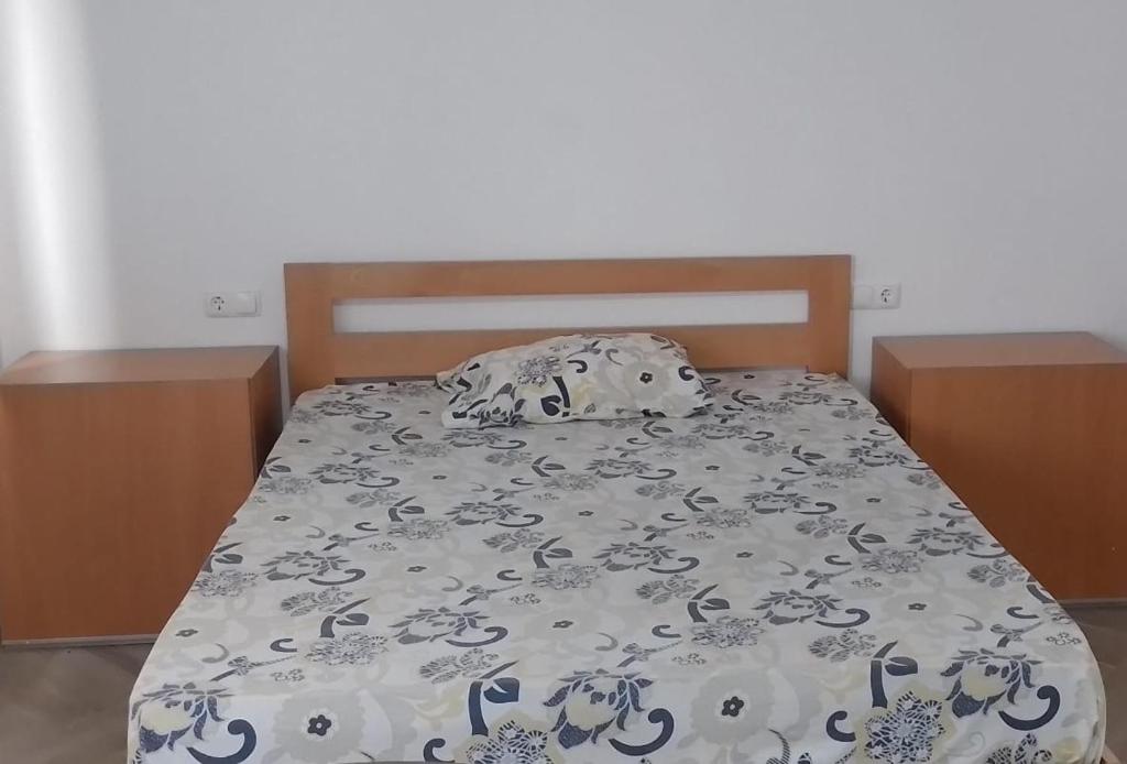 uma cama com um cobertor e almofadas em Apartamento Noz Kaza T2 Ilha do Maio em Calheta Do Maio