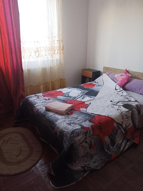 een slaapkamer met een bed met een quilt bij Camere in regim hotelier in Calafat