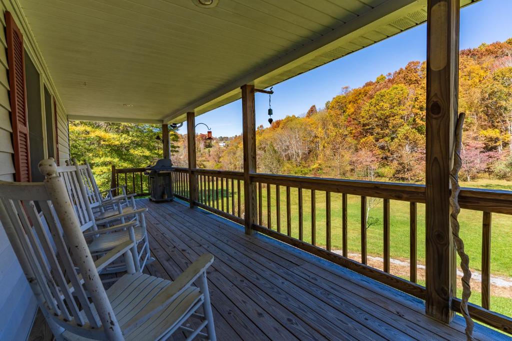 2 Schaukelstühle auf einer Veranda mit Waldblick in der Unterkunft Creekside Paradise - A Peaceful Family Focused Retreat on a Flowing Creek in Sparta