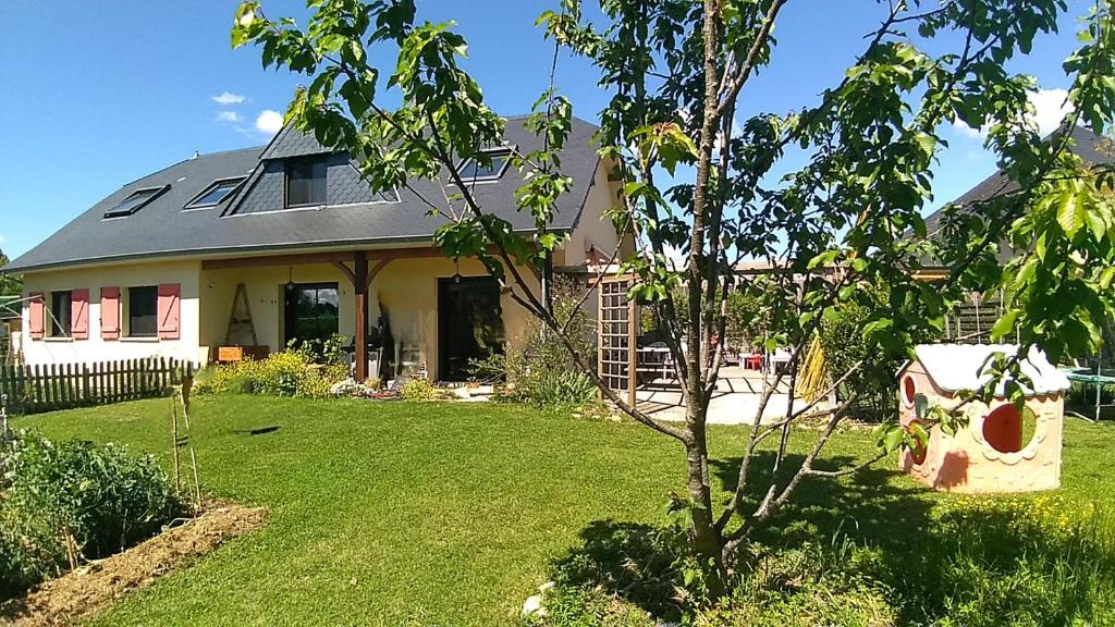 una casa con un patio con un árbol en Plain pied au vert, en Oloron-Sainte-Marie