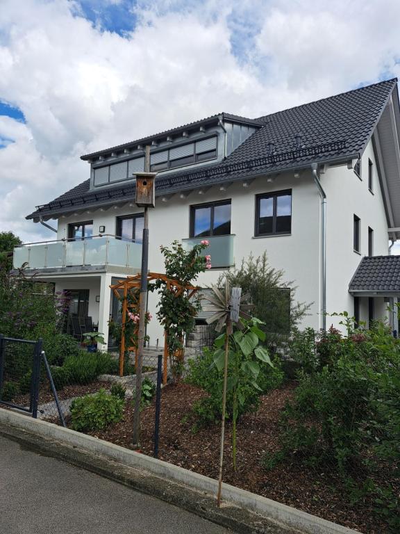 ein weißes Haus mit schwarzem Dach in der Unterkunft Rosenbogen in Bad Wörishofen