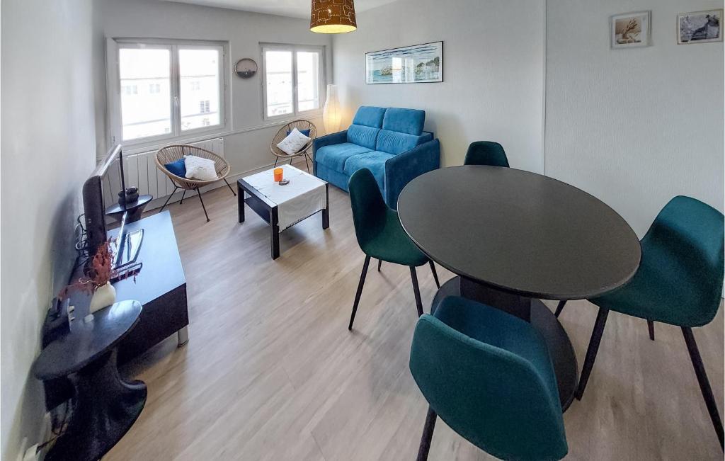 ein Wohnzimmer mit einem Tisch, Stühlen und einem Sofa in der Unterkunft Cozy Apartment In Royan With Wifi in Royan
