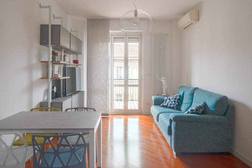 - un salon avec un canapé bleu et une table dans l'établissement Isola Milano apartment, à Milan
