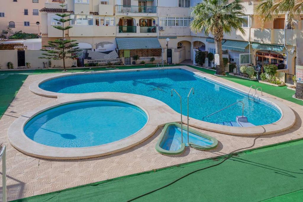 uma piscina com escorrega em frente a um edifício em Apartment Santana -19 at Beach with Pool, Garage and Lift em Torrevieja