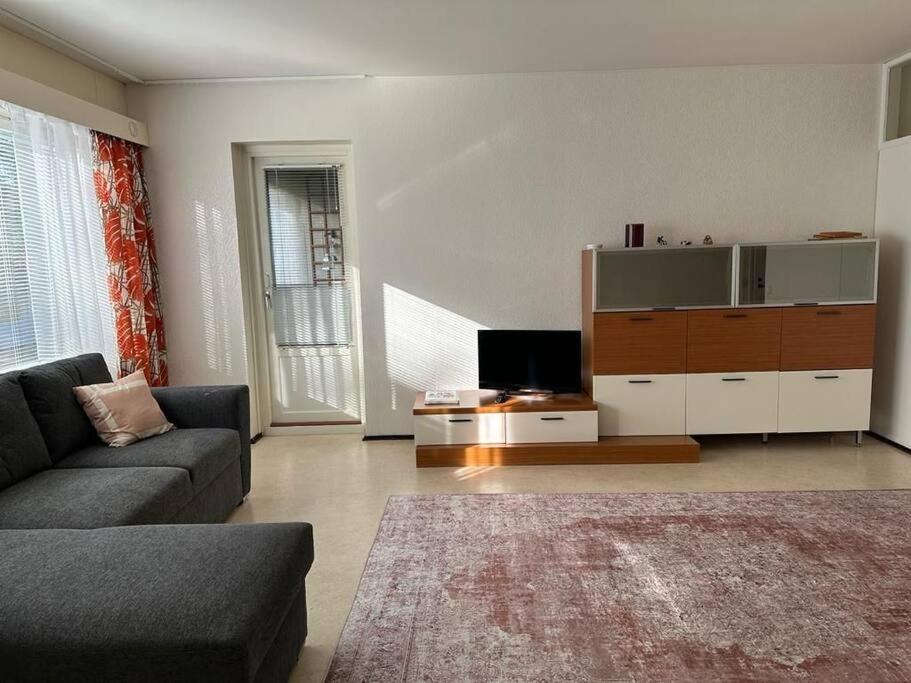 a living room with a couch and a flat screen tv at Welcomly apartment MILA in Kotka