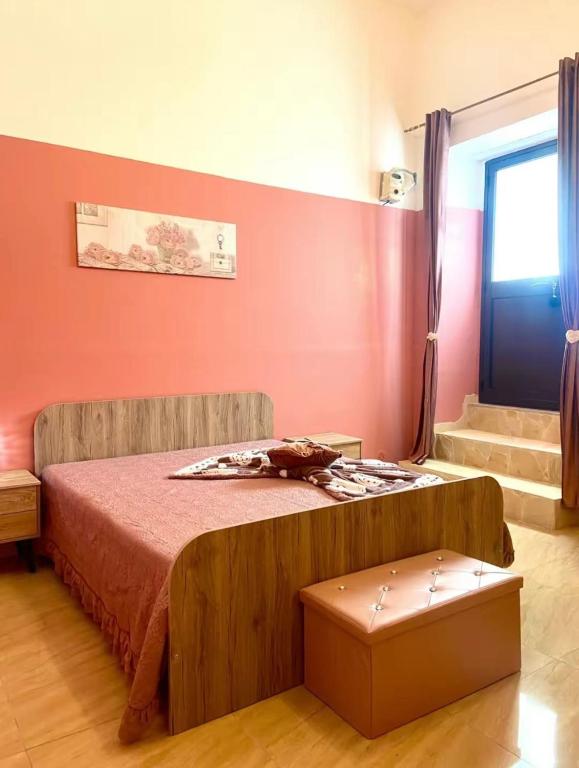 ein Schlafzimmer mit einem Bett mit einer roten Wand in der Unterkunft House 55 in Catania