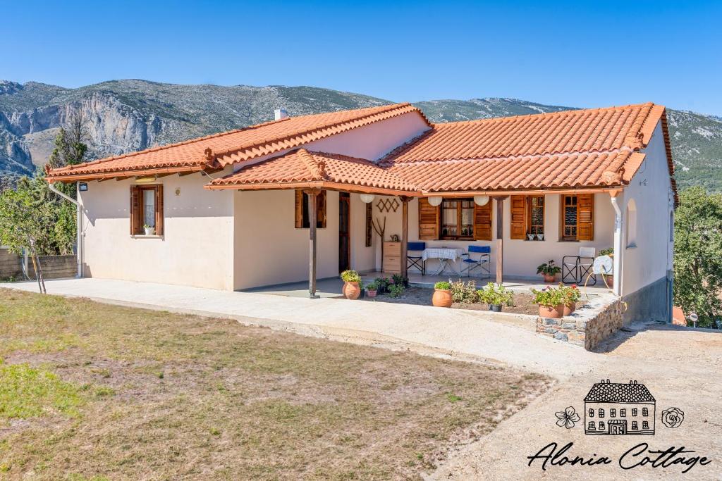 a house with a mountain in the background at Alonia Cottage in Episkopí