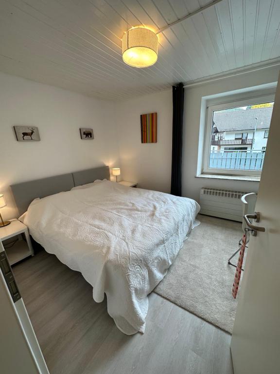 1 dormitorio con cama blanca y ventana en Unterkunft zur Sternblume, en Bruchweiler-Bärenbach