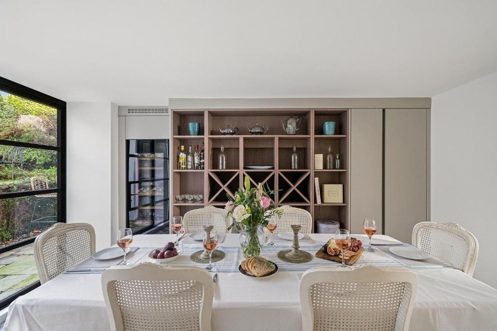 uma sala de jantar com uma mesa branca e cadeiras em The Lodge em Strete