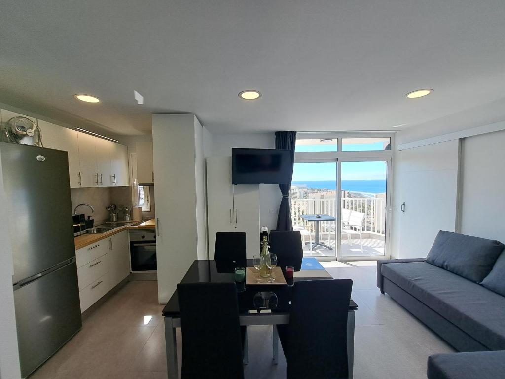 een keuken en een woonkamer met een bank en een tafel bij Panoramic Floor - Las Americas in Playa de las Americas