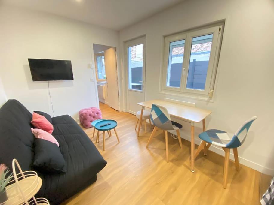un salon avec un canapé, une table et des chaises dans l'établissement L'hortentia T avec terrasse et salle de sport, à Amiens