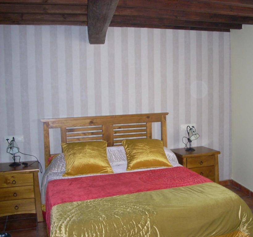 1 dormitorio con 1 cama con almohadas de oro y 2 mesitas de noche en Casa Rural La Cenicienta, en Sancti-Spíritus