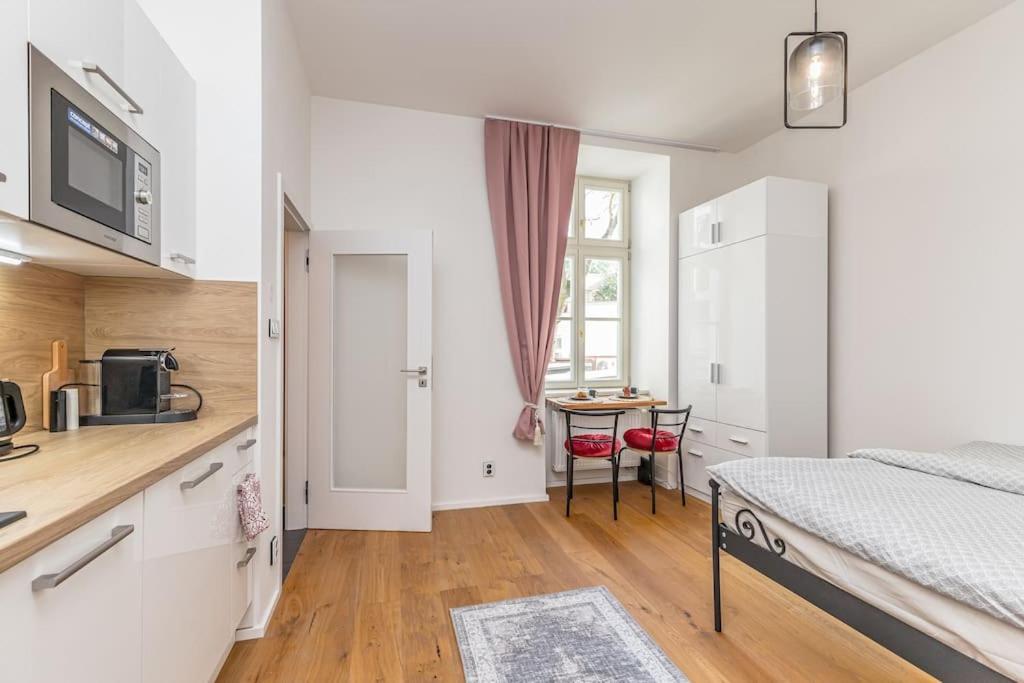 sypialnia z łóżkiem oraz kuchnia ze stołem w obiekcie Cozy quiet new apartment in Karlin square w Pradze