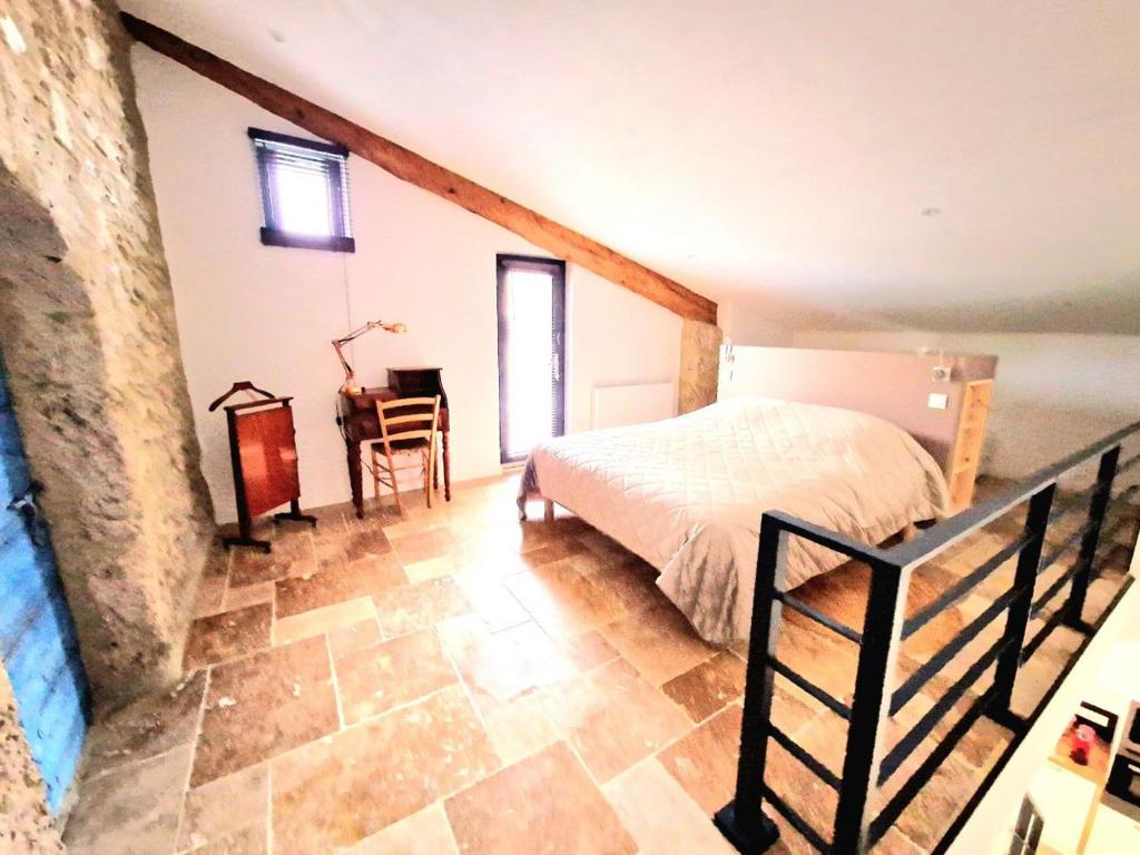 1 dormitorio con 1 cama y escritorio en una habitación en Gîtes de charme - Gîtes VITAL, en Peyrus