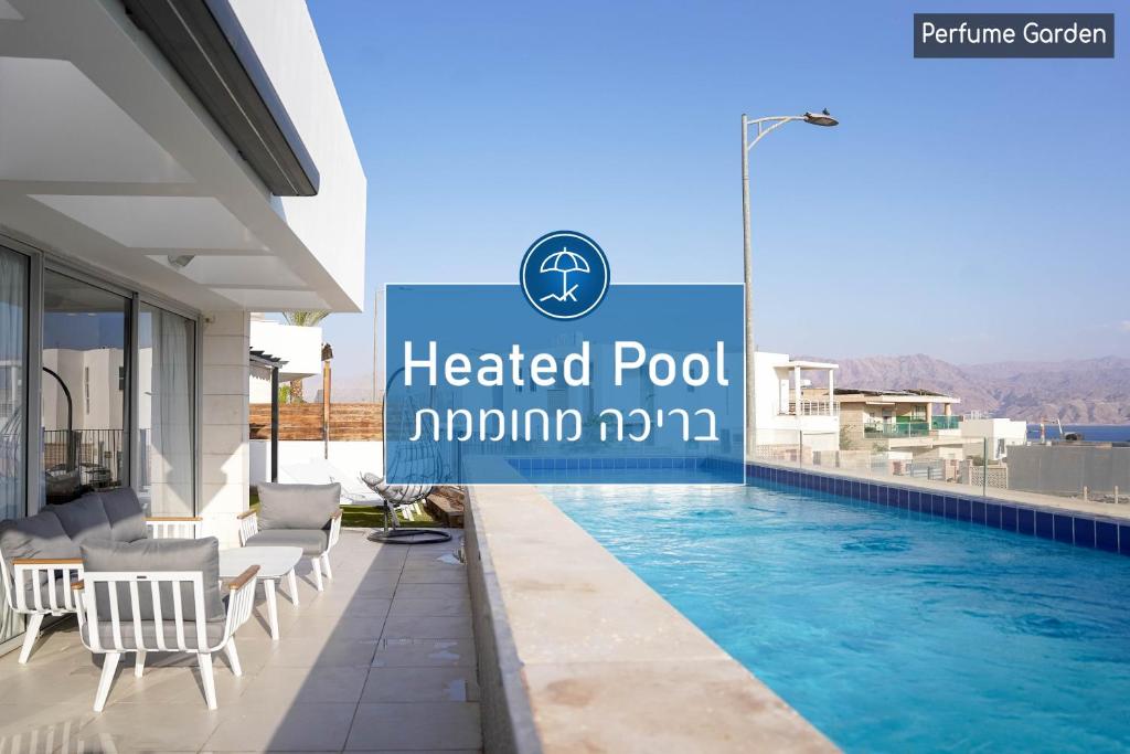a hotel pool with chairs and a sign that reads heated pool moroni kmm at YalaRent Mountainside Luxury apartments with Private Pool in Eilat