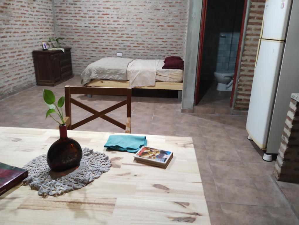 1 dormitorio con 1 cama y un jarrón en el suelo en Departamento monoambiente en 