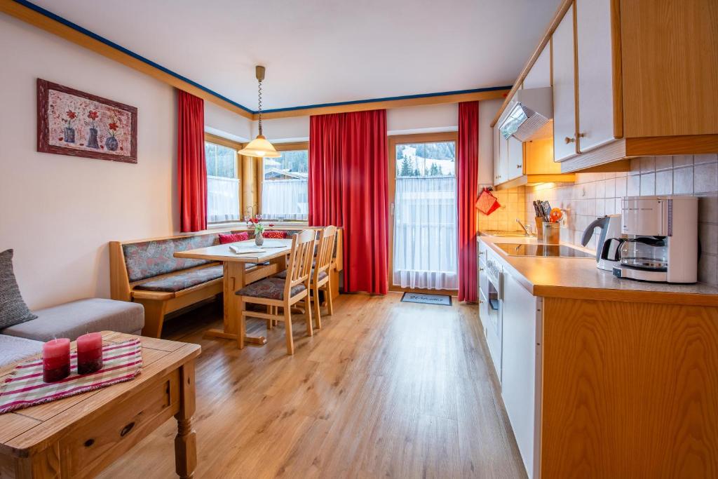 cocina y sala de estar con mesa en Apartment Bacher Nr.2, en Wald im Pinzgau