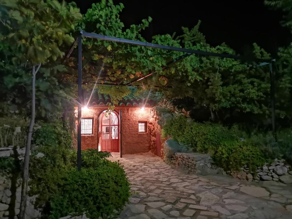 un camino de piedra que conduce a una puerta roja por la noche en Cueva El Parral, en Pegalajar