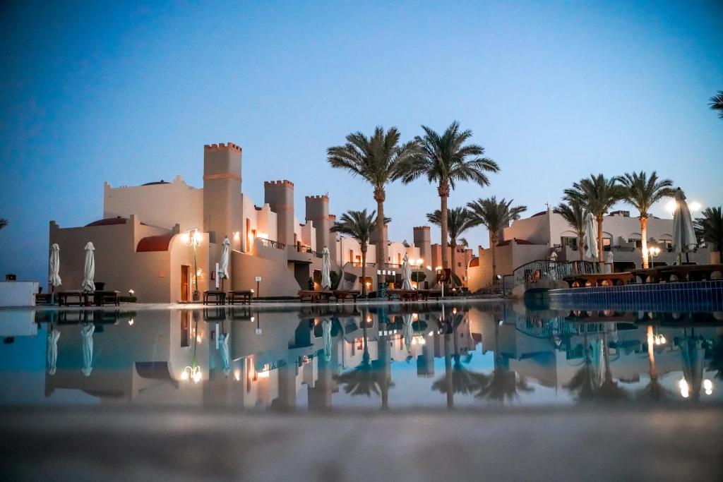 Blick auf ein Resort mit Palmen und einem Pool in der Unterkunft Sentido Akassia Beach in Al-Qusair