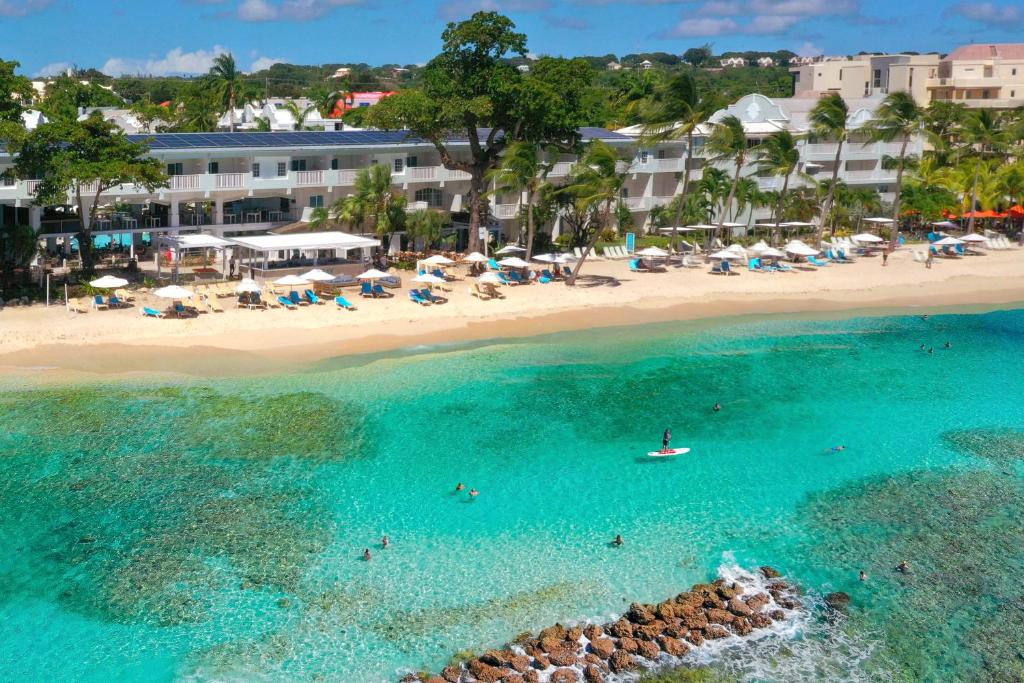 an aerial view of a beach with people in the water at Sugar Bay Barbados - All Inclusive in Bridgetown