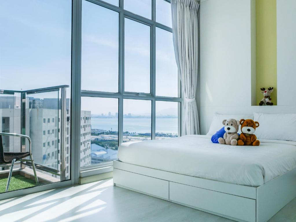 a bedroom with a bed with two teddy bears on it at Penang Straits Garden Condominium Georgetown in George Town