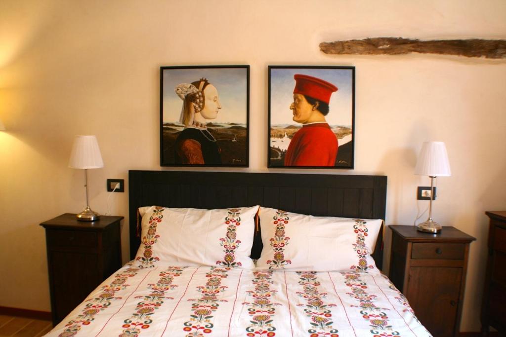 een slaapkamer met een bed met drie foto's aan de muur bij Torricini Skyline in Urbino