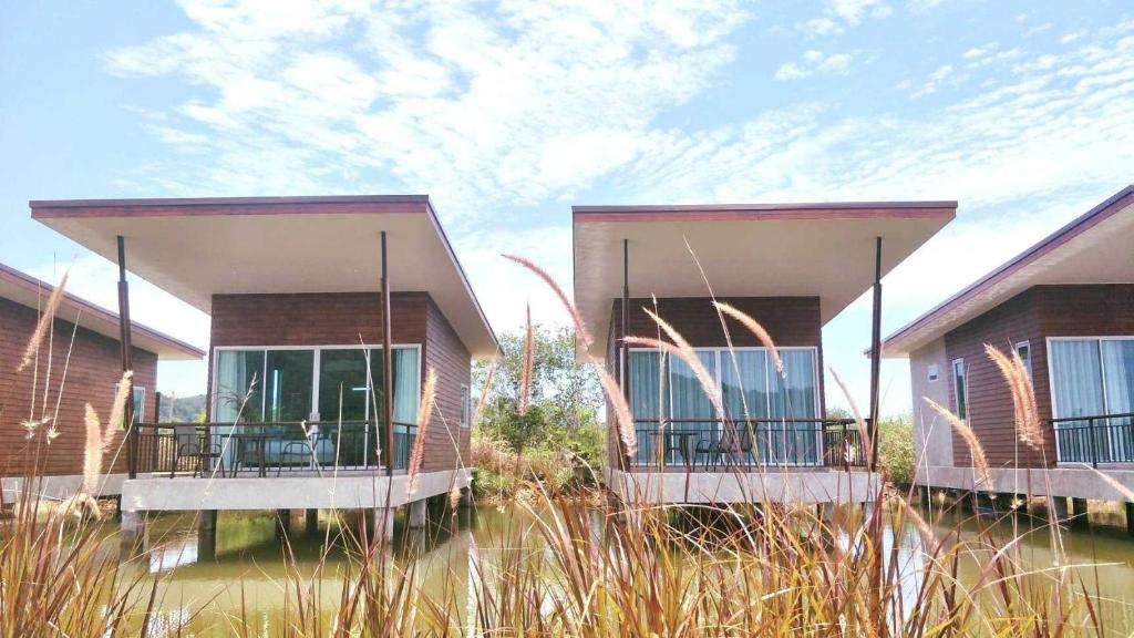 two houses with balconies in a field of tall grass at Ko Lanta Amantra Lake View Resort in Ko Lanta