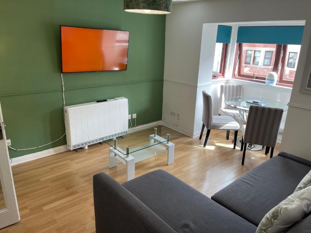 Coastal Apartment 2 Bedrooms, Sleeps upto 6, Free Parking في Prestonpans: غرفة معيشة مع أريكة وطاولة