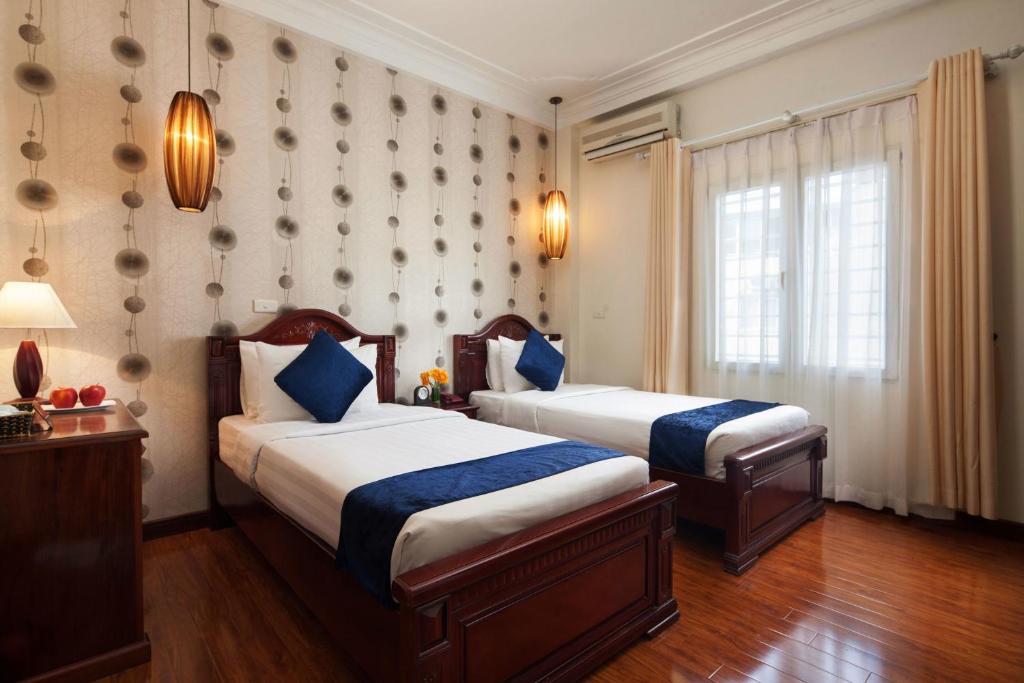 Postel nebo postele na pokoji v ubytování Hanoi Golden Moon Hotel & Travel