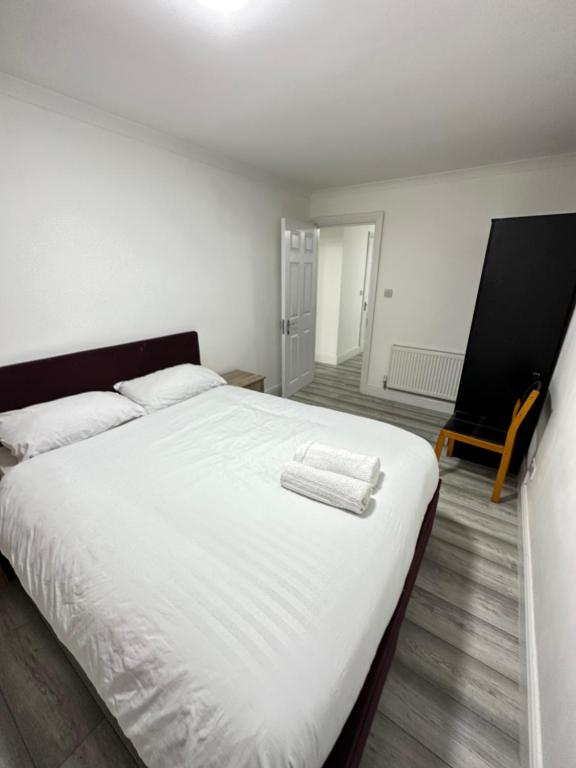 a bedroom with a white bed with two towels on it at Nice 3 bedroom Bayswater in London