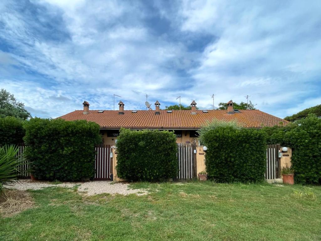 a house with hedges in front of a building at Casa Vacanze La Riserva Maccarese in Maccarese