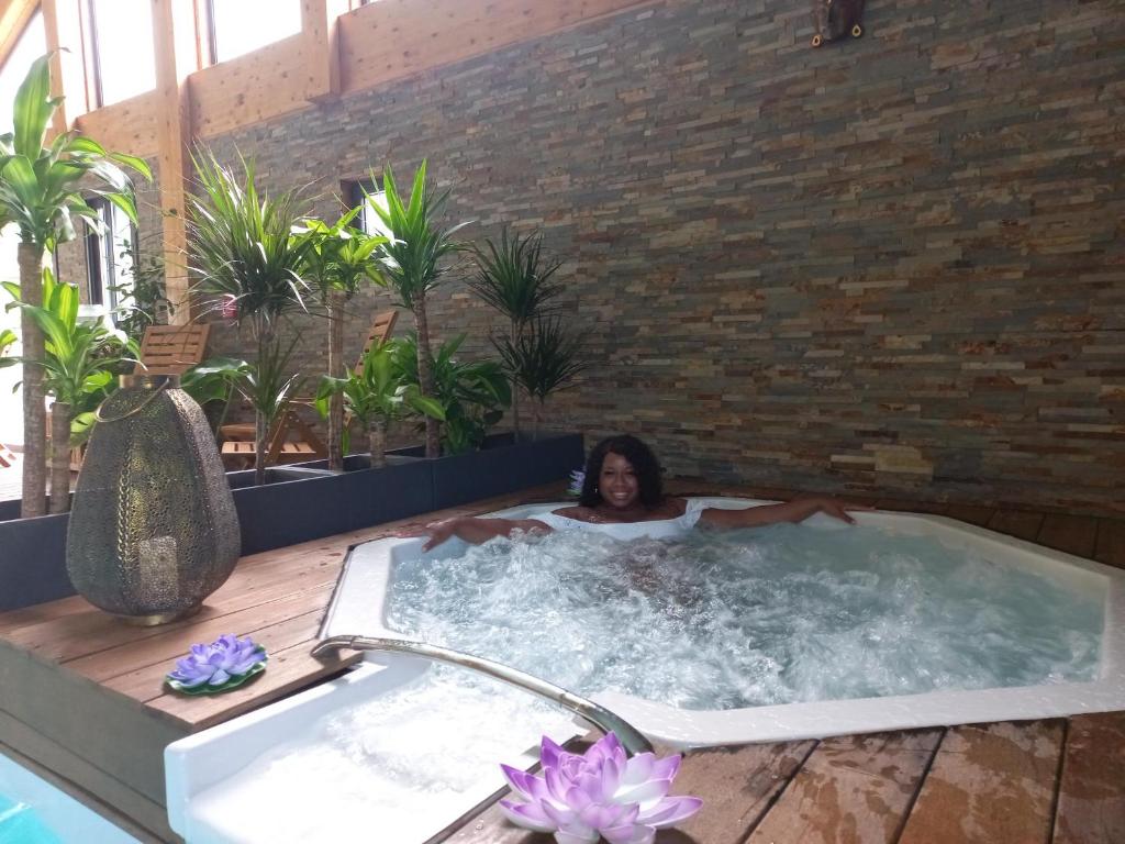 a woman in a jacuzzi tub in a building at Les Chalets du Lac Belcaire in Belcaire