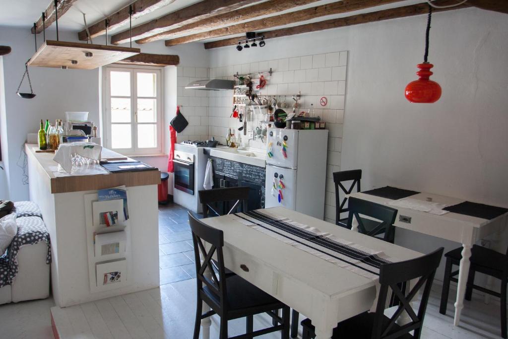 een keuken met een tafel en stoelen en een keuken met een koelkast bij Houses of Motovun in Motovun