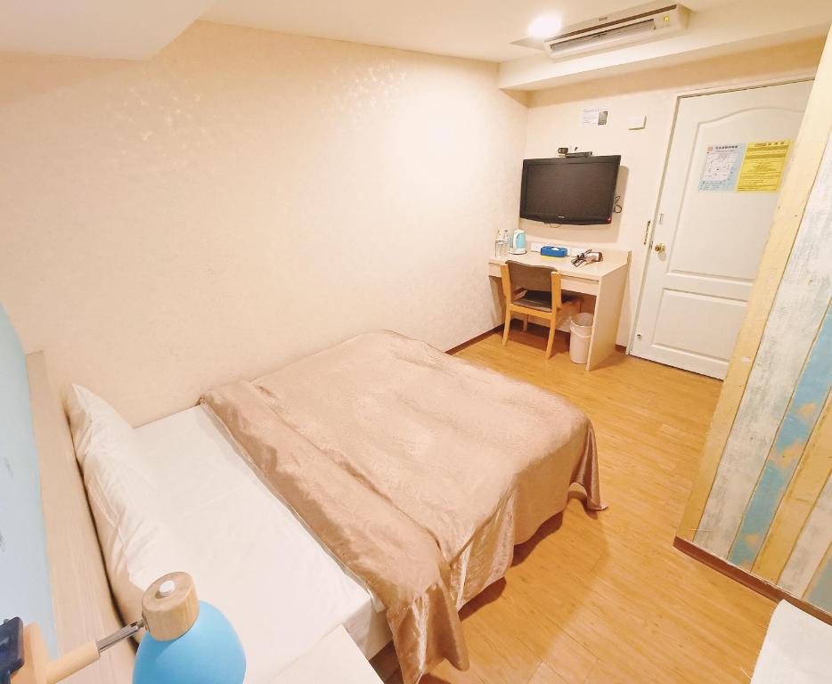 a hospital room with a bed and a desk at Sanduo Hotel in Kaohsiung