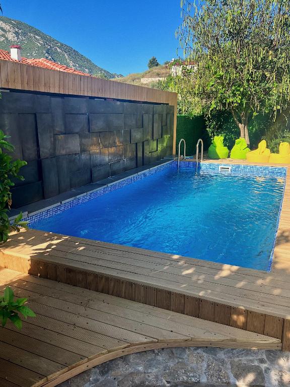 a swimming pool in a backyard with a wooden deck at Lb Boutique Hotel in Kumluca