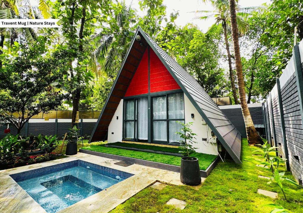 a small house with a red roof and a swimming pool at Oh - Bali Villa by Travent Mug in Rāmanagaram